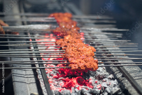 Smoky sheek kabab cooked on a coal fire, Famous street food sheek kabab being cooked over a grill photo