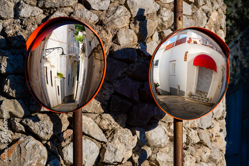 Foto Two circular old traffic mirrors with red frames reflecting narrow streets in a village on Capri island, Italy