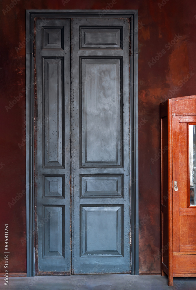 Vintage teal green wooden door on dark red exterior wall. Retro interior concept with copy space.