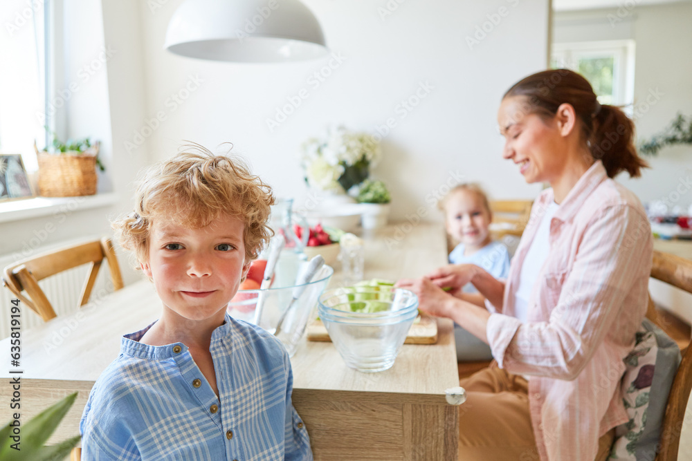 Smiling son with mother cutting fruits at home Smiling son with mother cutting fruits at home