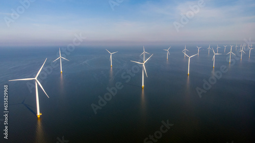 Windmill park in the ocean, drone aerial view of windmill turbines generating green energy electric, windmills isolated at sea in the Netherlands