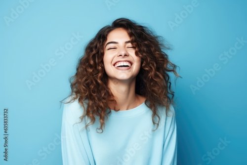 A Woman With Curly Hair Smiling And Looking Up