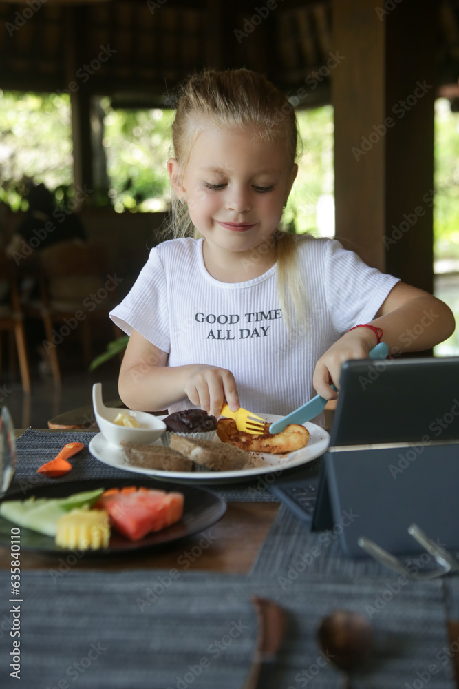 Cute 5 years old girl having kids meal at the restaurant	