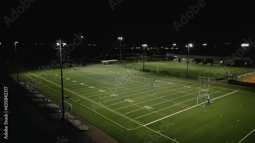 Drone Shot of the Entire Stadium with a Football Match or Practice. Teams Play at a Night Stadium Outside the City. Football Tournament. Canada, Dartmouth. photo