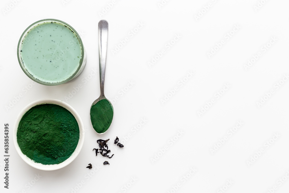 Spirulina algae powder in bowl and cold milk latte drink, top view Spirulina algae powder in bowl and cold milk latte drink, top view