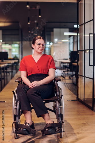 A modern young businesswoman in a wheelchair is surrounded by an inclusive workspace with glass-walled offices, embodying determination and innovation in the business world © .shock