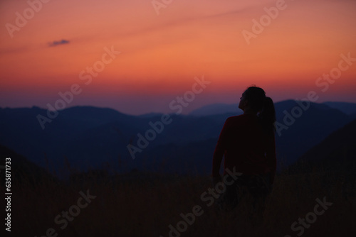 Silhouette of a woman enjoying peacefully in nature.
