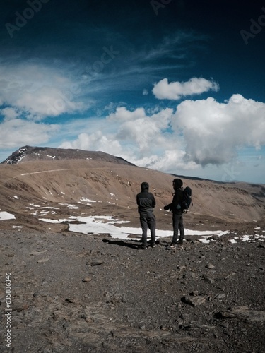 dos excursionistas mirando el pico del mulhacén en las montañas de sierra nevada en españa