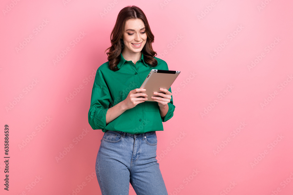 Photo of sweet cute woman dressed green shirt communicating modern gadget empty space isolated pink color background Photo of sweet cute woman dressed green shirt communicating modern gadget empty space isolated pink color background