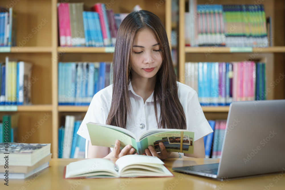 Portrait of an Asian girl college student studying in library doing project assignment and preparing for examination Portrait of an Asian girl college student studying in library doing project assignment and preparing for examination