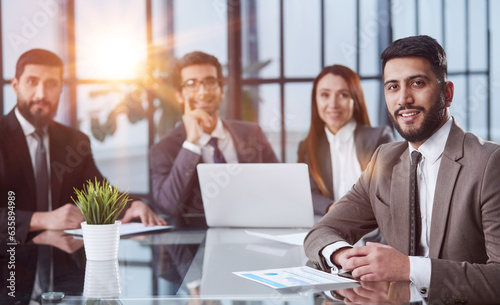 Office days. Group of business people sitting together at a table and looking at the camera