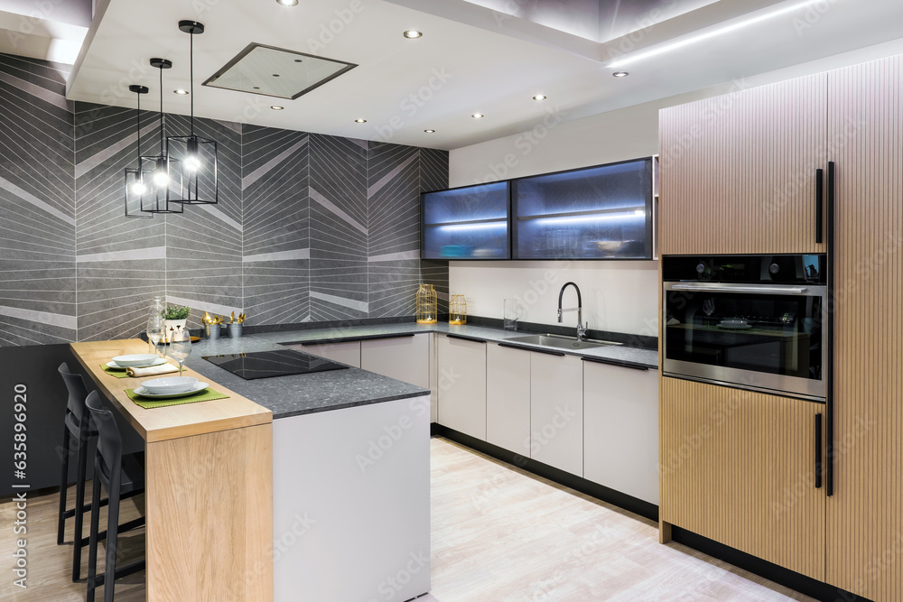 Fototapeta premium Modern kitchen interior decorated with built in appliances in illuminated lights