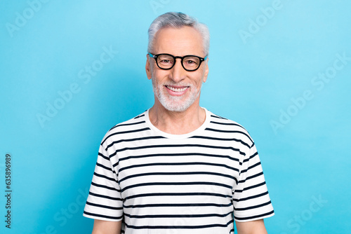 Photo portrait of handsome grandad oculist eyesight beaming smile wear trendy striped clothes isolated on blue color background
