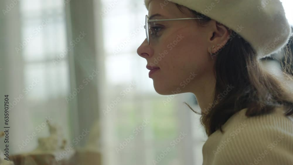 Young French woman looking at exhibits in a Parisian museum, indoors Young French woman looking at exhibits in a Parisian museum, indoors