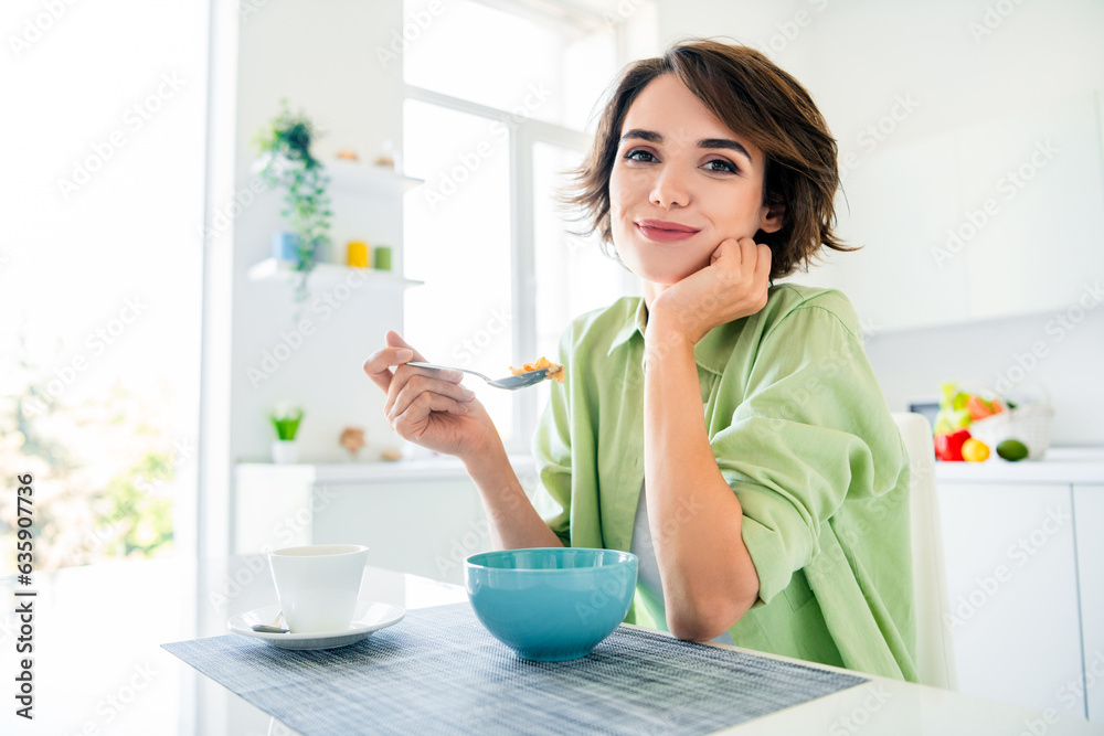 Photo of adorable pretty girl wear green shirt eating healthy super food smiling indoors kitchen room
