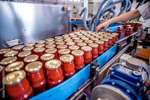 The working process of production of tomatoes to canned food and vegetable factory. Workers on the production of canned food. Processing tomato. Sicily Italy.