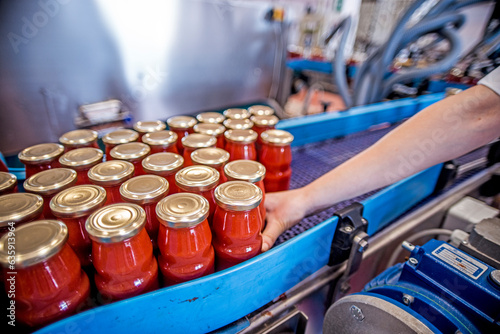 The working process of production of tomatoes to canned food and vegetable factory. Workers on the production of canned food. Processing tomato. Sicily Italy.