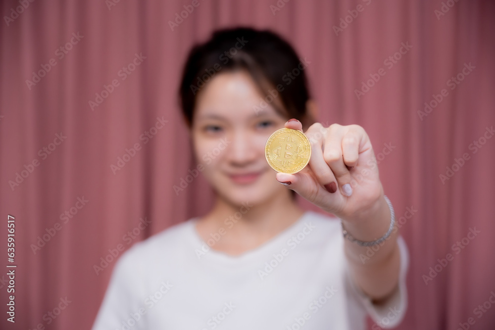Portrait of a smiling Asian woman wear white shirt and holding banknotes or money us dollar and bitcoin BTC included with Cryptocurrency hand picked on pink background. Portrait of a smiling Asian woman wear white shirt and holding banknotes or money us dollar and bitcoin BTC included with Cryptocurrency hand picked on pink background.