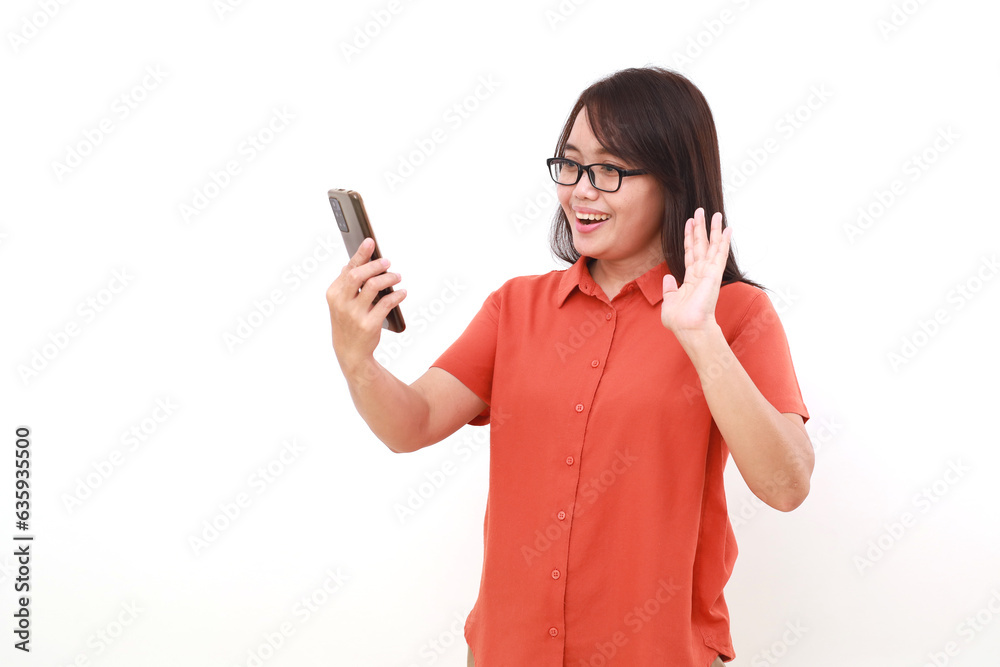Excited young asian woman making video call with her cell phone. Isolated on white Excited young asian woman making video call with her cell phone. Isolated on white