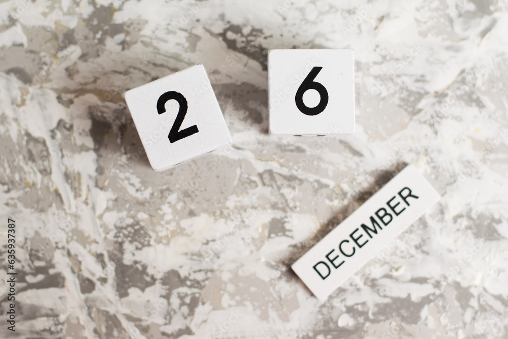 Flatlay, wooden calendar with date December 26 on white textured background. Flatlay, wooden calendar with date December 26 on white textured background.