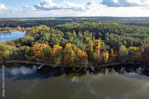 Aerial shot of beautiful lake surrounded by forest in a calm autumn day. Germany. © Igor Syrbu