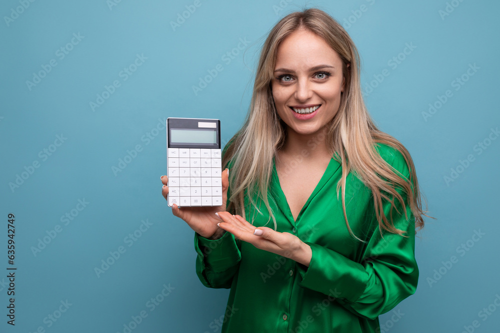 european smiling stylish blonde girl with a calculator on a blue background european smiling stylish blonde girl with a calculator on a blue background