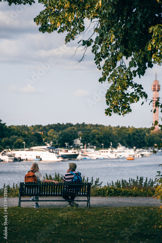 Two people talk while sitting on a bench in Stockholm, Djurgården 