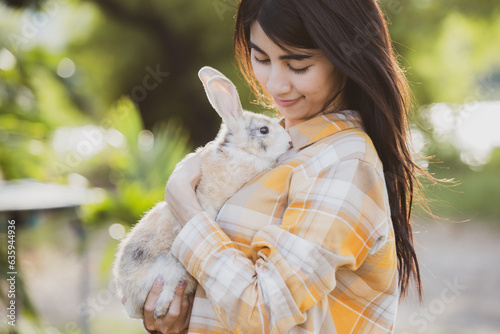 relationships of cheerful rabbit and happy young human girl, Asian woman holding and carrying cute rabbit with tenderness and love. Friendship with cute easter bunny. Happy of Easter's Day