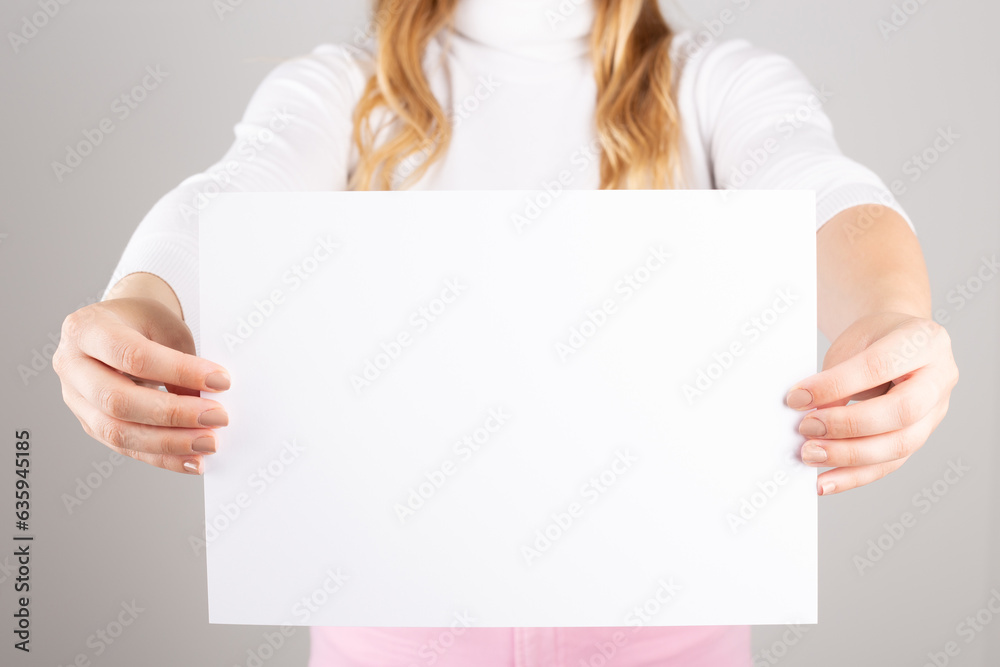 an anonymous woman shows a blank sheet of paper. Space for text an anonymous woman shows a blank sheet of paper. Space for text