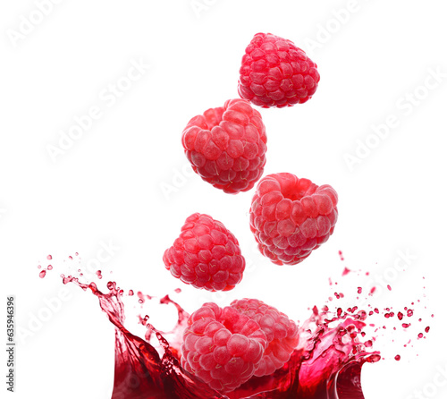 Raspberries falling into juice on white background