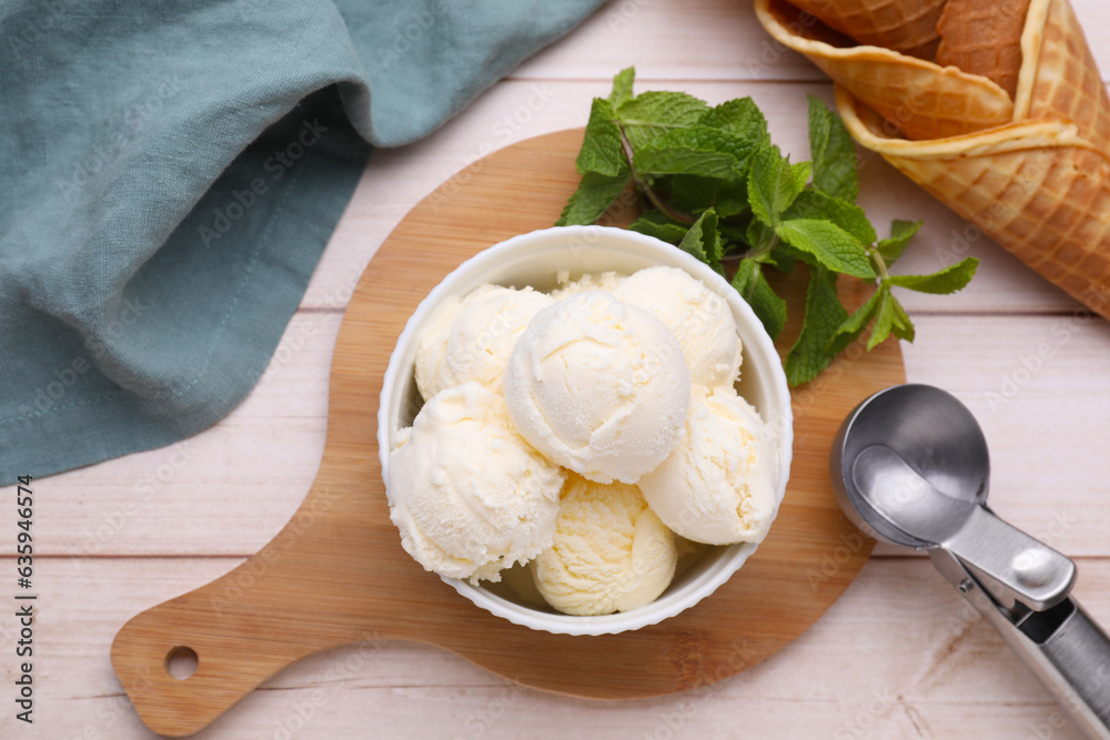 Bowl of ice cream, cones and mint leaves on light wooden table, flat lay Bowl of ice cream, cones and mint leaves on light wooden table, flat lay