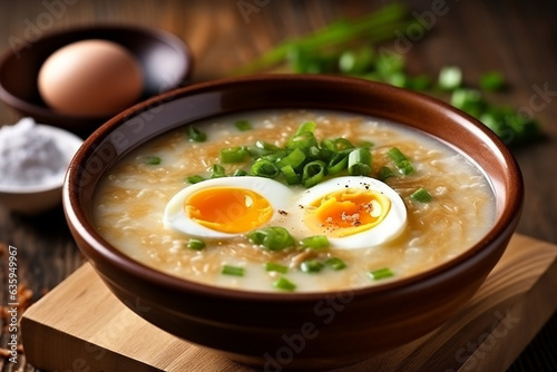 Porridge rice gruel with boiled eggs in bowl on table