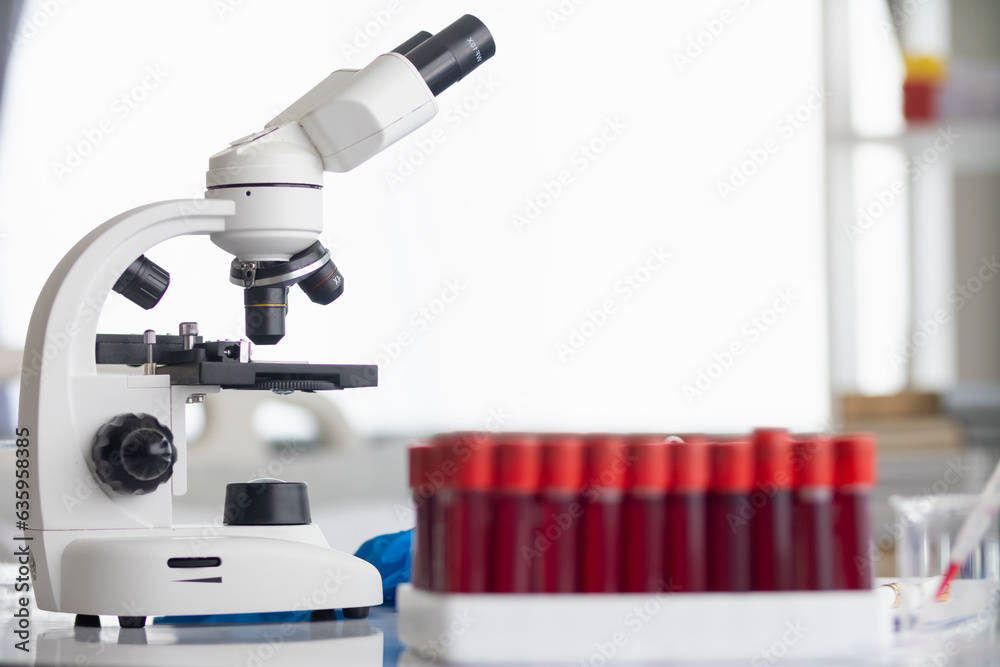 Test tubes and microscope are placed on white table in lab to prepare virologists who want to use lab to examine samples of virus they received from epidemic. Medical equipment for use in laboratorie Test tubes and microscope are placed on white table in lab to prepare virologists who want to use lab to examine samples of virus they received from epidemic. Medical equipment for use in laboratorie