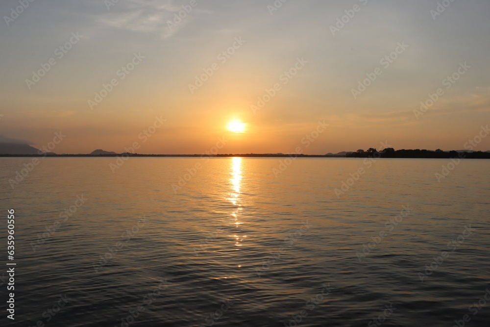 Obraz premium Serene Sunset Over Tranquil Waters, A Captivating View at village in sri lanka