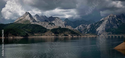 Scenic view of the Elsa river with mountains and clouds in the background in Riao, Spain. photo