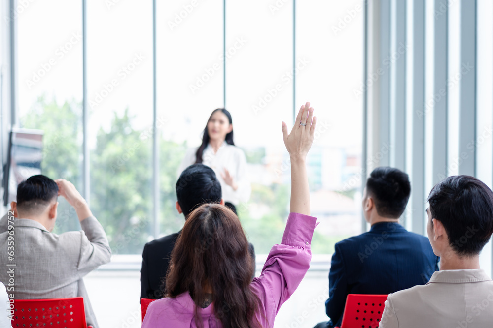 Business person raising hand during seminar. Hand up in conference asking to answer a question in business meeting room and seminar class.