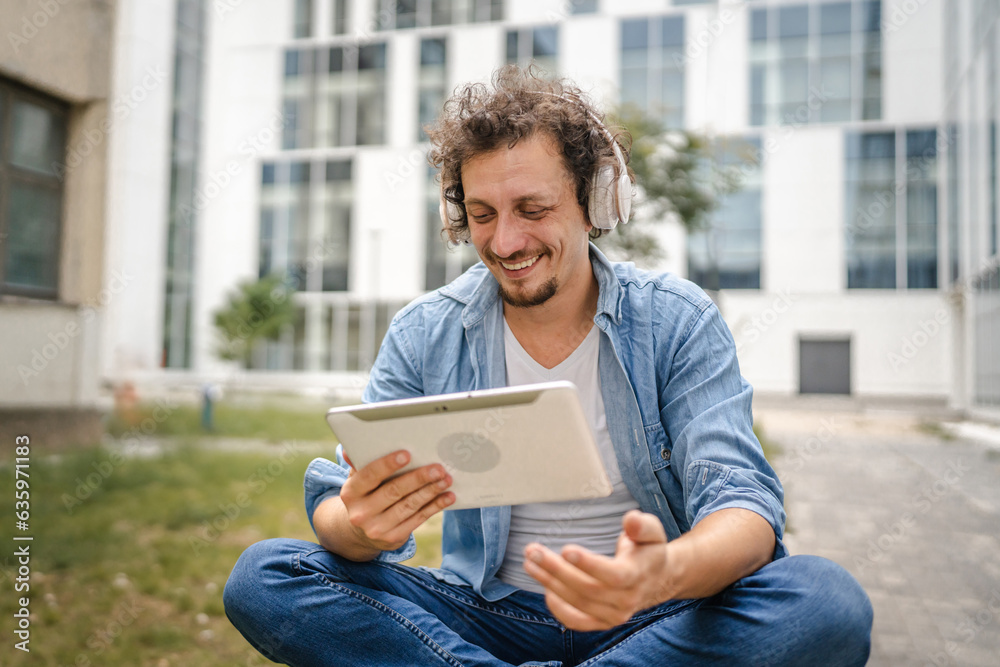 man sit in front of modern building use digital tablet watch movie man sit in front of modern building use digital tablet watch movie