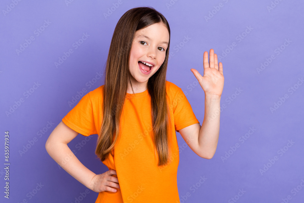 Portrait of positive nice schoolgirl with long hairdo wear stylish t-shirt waving palm arm on waist isolated on violet color background Portrait of positive nice schoolgirl with long hairdo wear stylish t-shirt waving palm arm on waist isolated on violet color background