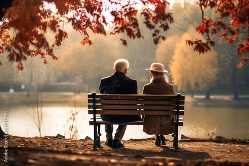 Senior couple sitting on a bench in a autumn park, back view. AI generated