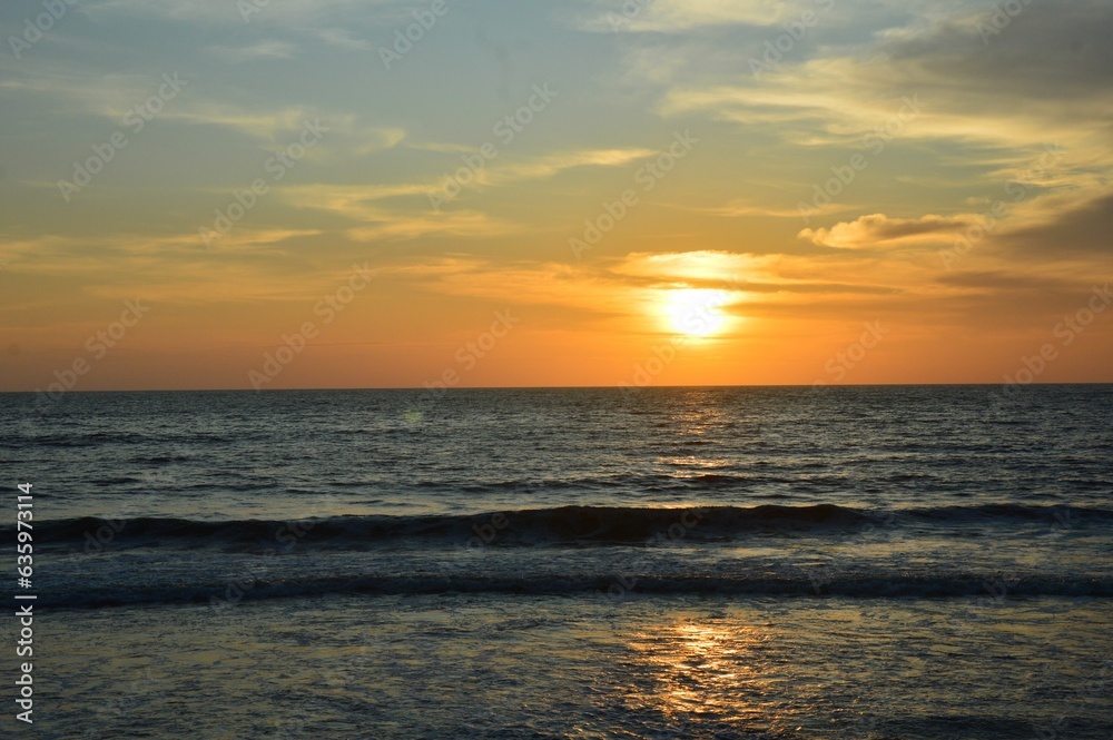 Beautiful golden sunset paints the sky over a serene blue ocean