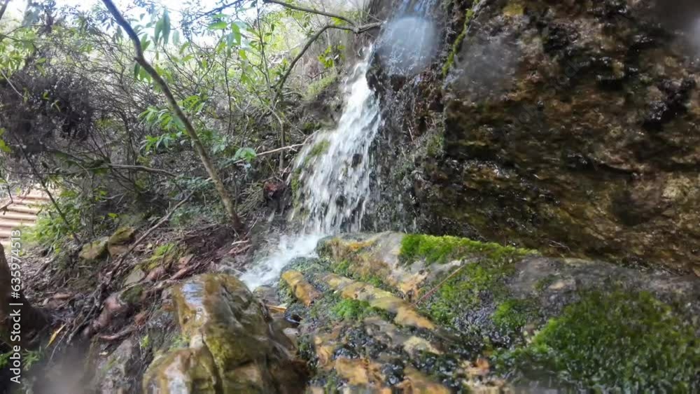 Closeup of heavy stream falling on mossy rocky stones in the forest Closeup of heavy stream falling on mossy rocky stones in the forest