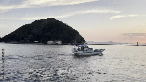 Boat driving in the sea with Kashima island off the coast of Hojo, Matsuyama in  Japan photo