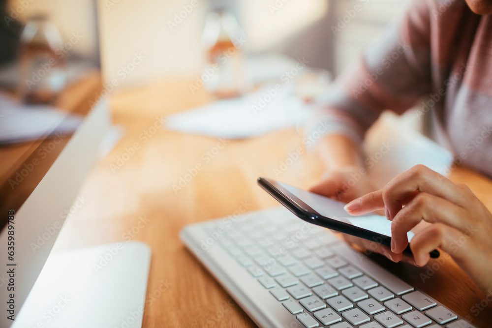 Young caucasian woman using a smart phone while working and studying at home Young caucasian woman using a smart phone while working and studying at home