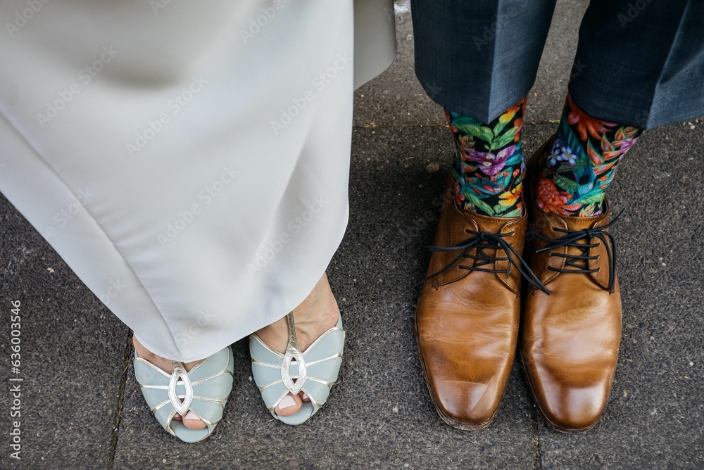 People standing side-by-side, wearing matching shoes and socks, against a plain background