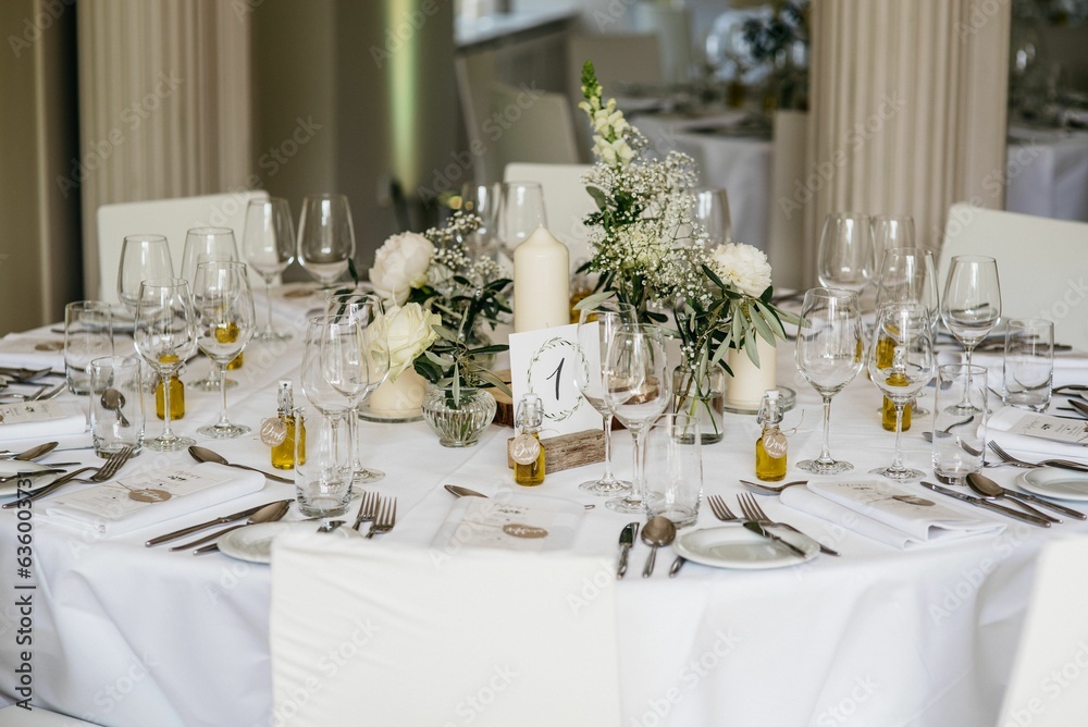 a table set with a table number, wine glasses and silverware