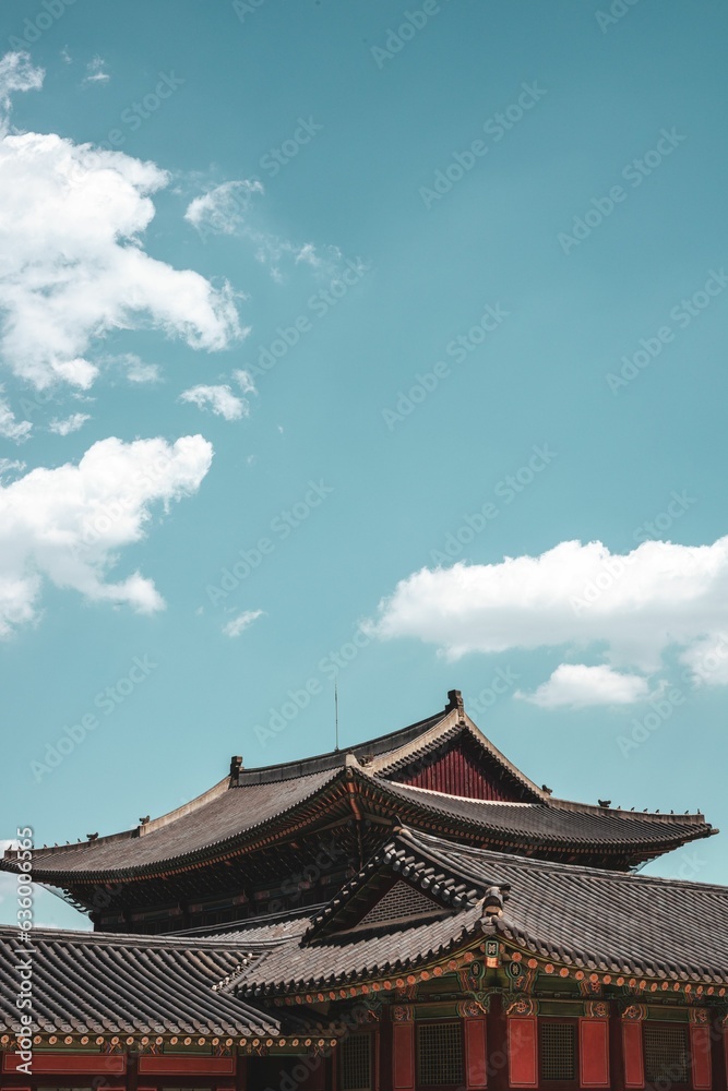 Vertical shot of a traditional Korean building under the sunlight and a blue sky Vertical shot of a traditional Korean building under the sunlight and a blue sky