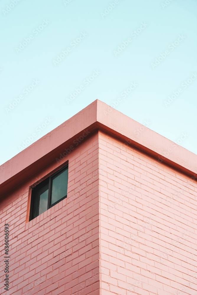 Vertical shot of a modern building angle under a blue sky and sunlight Vertical shot of a modern building angle under a blue sky and sunlight