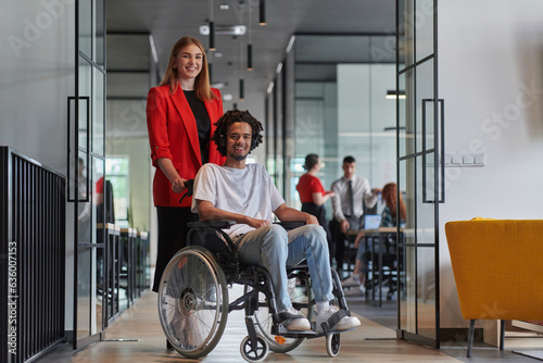 A group of young business people in a modern glass-walled office captures the essence of diversity and collaboration, while two colleagues, including an African American businessman in a wheelchair