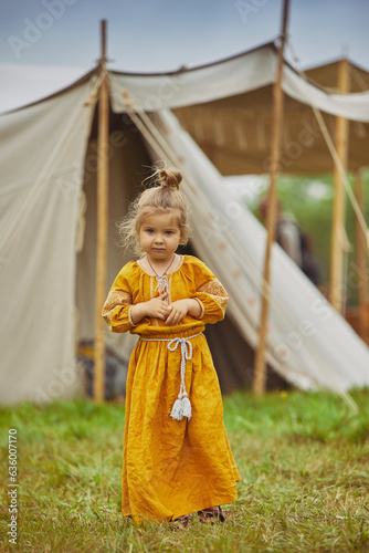 Charming child in embroidered dress at the viking festival in Denmark photo