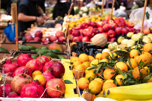 Fototapeta Naklejka Na Ścianę i Meble -  Fruit and vegetable stall in a street market in Naples in Italy. Signs with prices in the background, oranges, bananas, pomegranates.